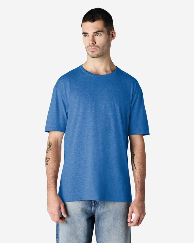 A model wearing a blue Gildan Softstyle adult T-shirt, paired with light denim jeans.