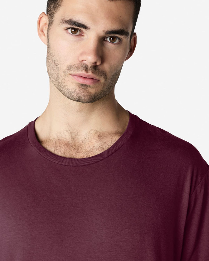 A close-up of a male model wearing a maroon Gildan Softstyle adult T-shirt with a round neckline.