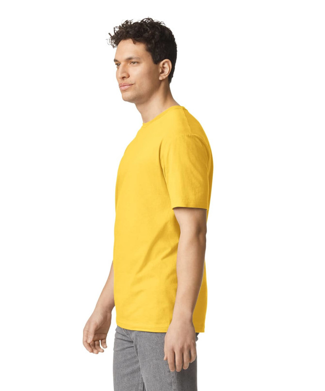 A yellow Gildan Softstyle adult T-shirt displayed on a model standing sideways. The shirt has a logo.
