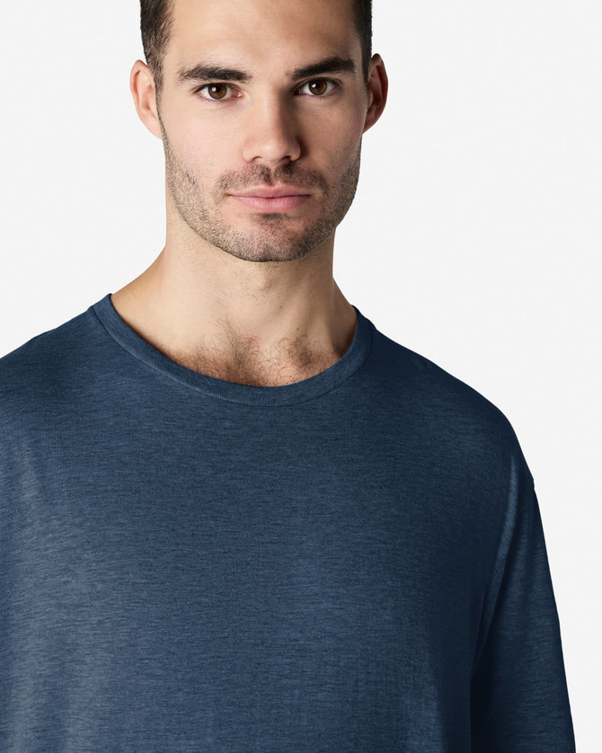 A navy blue Gildan Softstyle adult t-shirt on a male model, featuring a casual crew neck design and a plain backdrop.