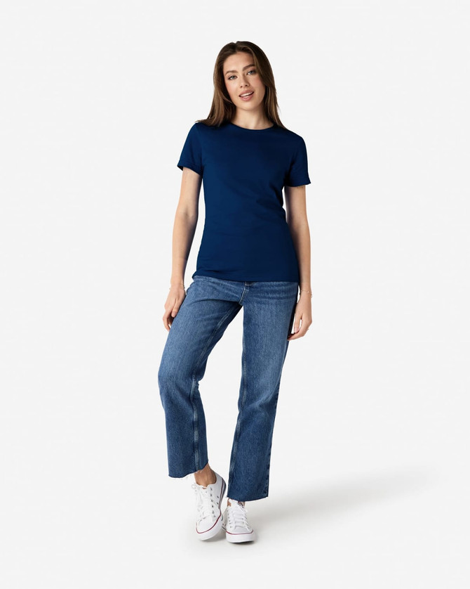 A navy blue ladies' T-shirt paired with light blue jeans and white sneakers. The shirt features a logo.