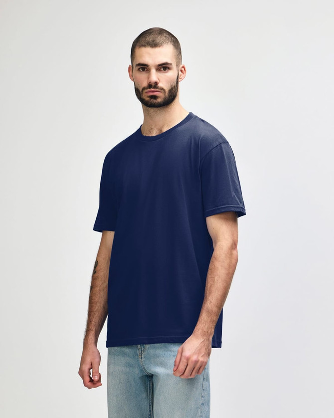 A navy blue Gildan Softstyle adult midweight T-shirt on a model, featuring a logo on the sleeve.