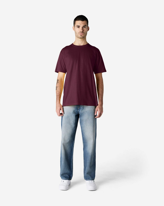 A maroon Gildan Softstyle adult midweight T-shirt displayed on a model, paired with black jeans and sneakers.