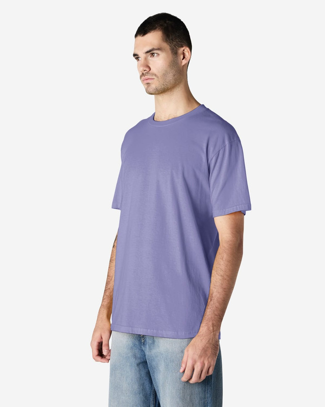 A purple Gildan Softstyle adult midweight T-shirt on a model, featuring a simple design and short sleeves.
