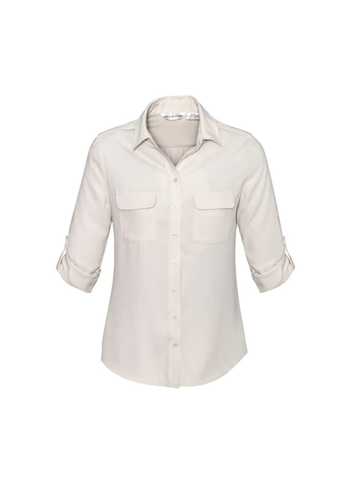A women's long sleeve button-up shirt in cream, featuring two front pockets and rolled-up sleeves. It has a logo.