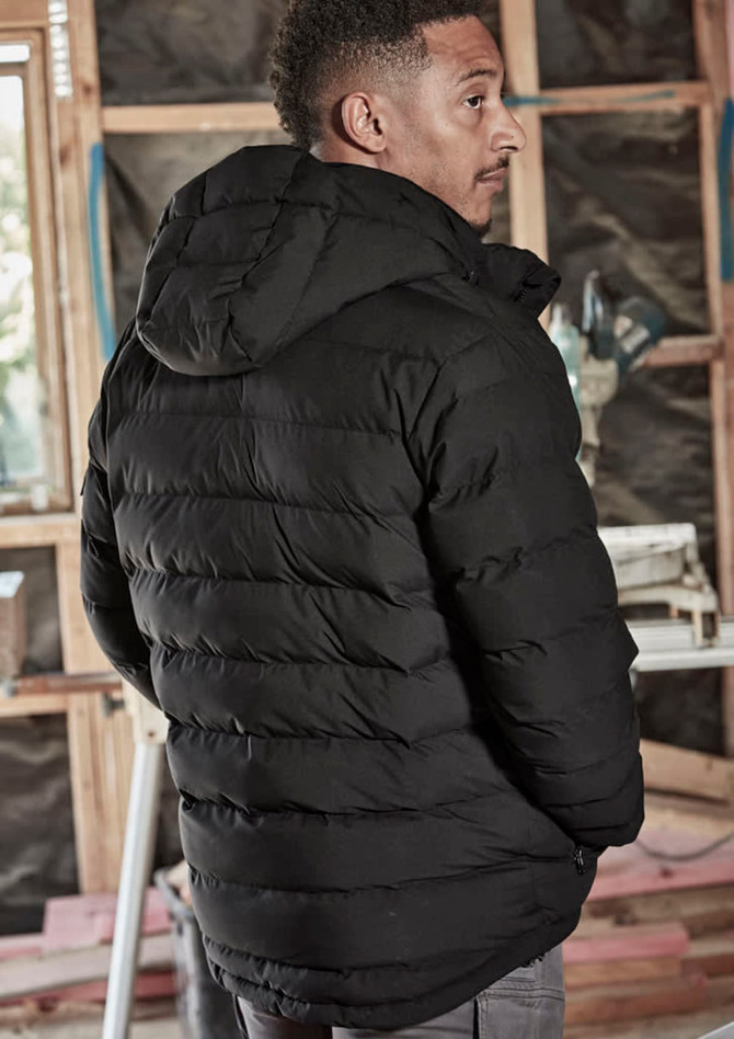A black unisex hooded puffer jacket with a quilted design, worn by a person from a side angle.