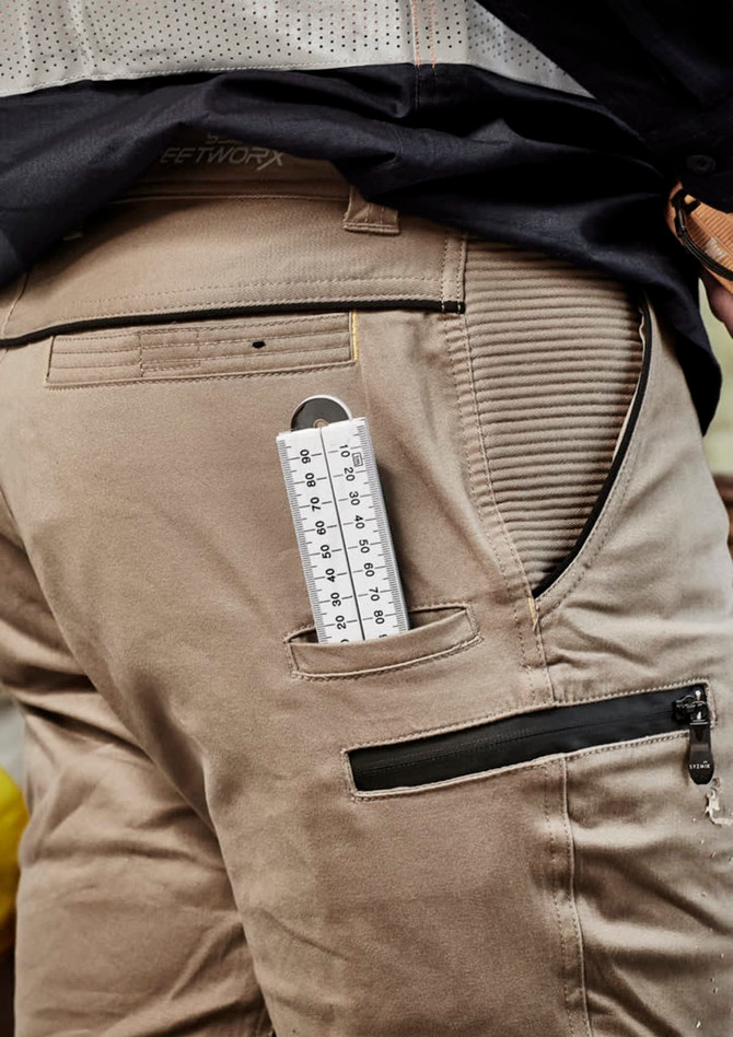 Men's Streetworx stretch pants in beige with a side pocket holding a measuring tool. Includes branding on the waistband.