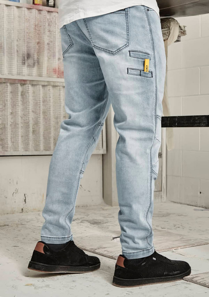 Men’s street-style stretch jeans in light blue, featuring pockets and a logo. Styled with black sneakers.