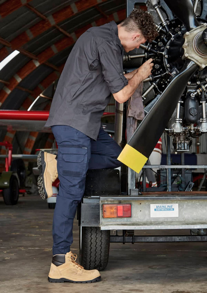 A rugged long sleeve button-up shirt in charcoal grey paired with navy cargo pants and beige work boots.
