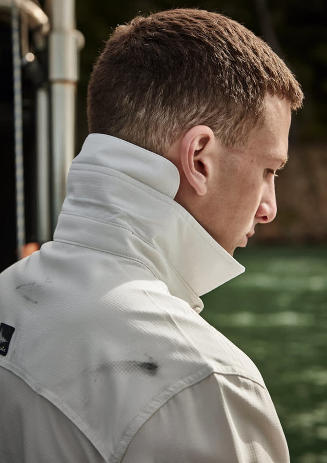 A long sleeve button-up shirt in white, featuring a high collar and casual fit. Includes a logo on the chest.