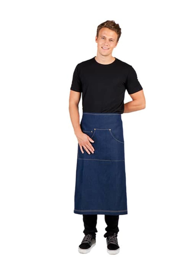 A long waist denim apron in blue with pockets, worn by a smiling man in a black T-shirt and jeans.