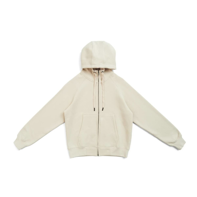 A cream zippered hoodie with a kangaroo pocket and drawstring hood. Features long sleeves and a branding logo.