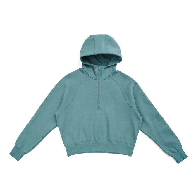 A half-zip jumper in a soft teal colour with a hood and long sleeves, featuring a logo on the front.