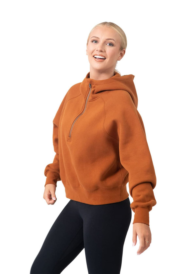A half-zip jumper in a warm rust colour featuring a hood and a relaxed fit. Includes a logo on the garment.
