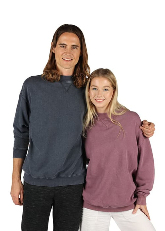 A man in a dark blue sweatshirt and a woman in a purple sweatshirt pose together, both wearing casual attire.