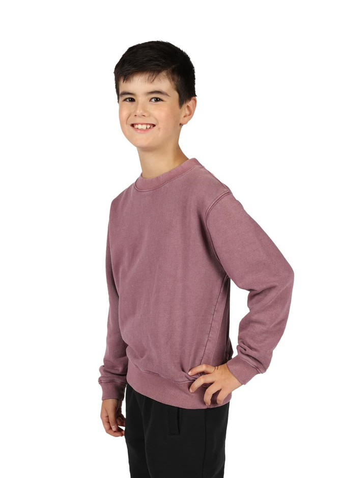 A unisex stone wash sweatshirt in a muted mauve colour, worn by a smiling child against a white background.