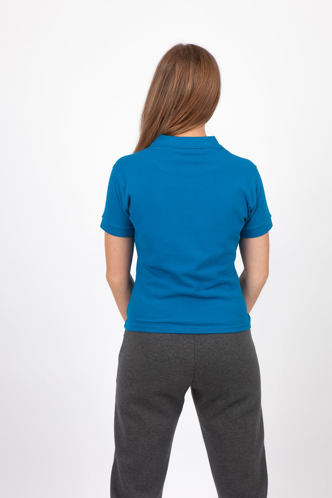 A blue women's cotton polo shirt viewed from the back, paired with grey pants. The shirt features a logo.