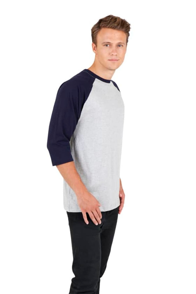 A light grey and navy blue unisex 3/4 sleeve raglan T-shirt displayed on a male model standing sideways.