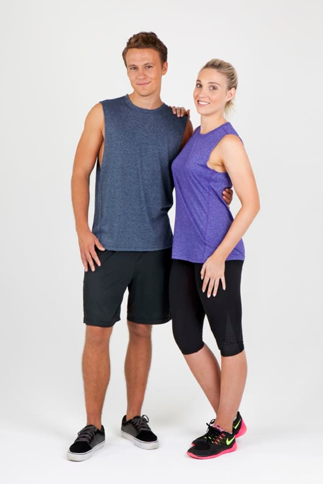 A man in a dark blue sleeveless tee and shorts stands beside a woman in a purple sleeveless tee and black leggings.