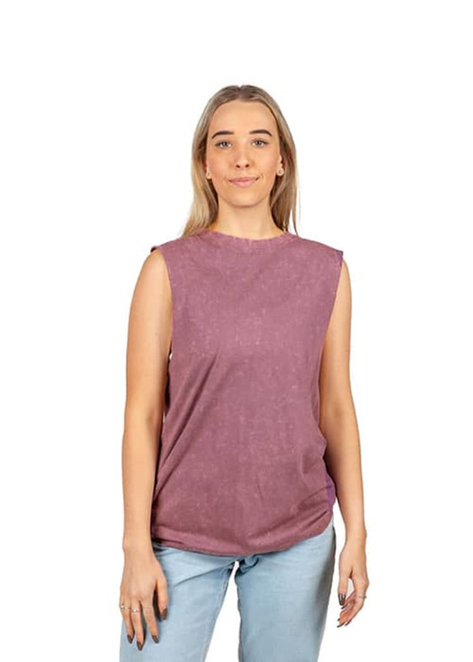 A woman wearing a stone-washed, sleeveless tank top in a mauve colour with a relaxed fit. The top has a branding logo.