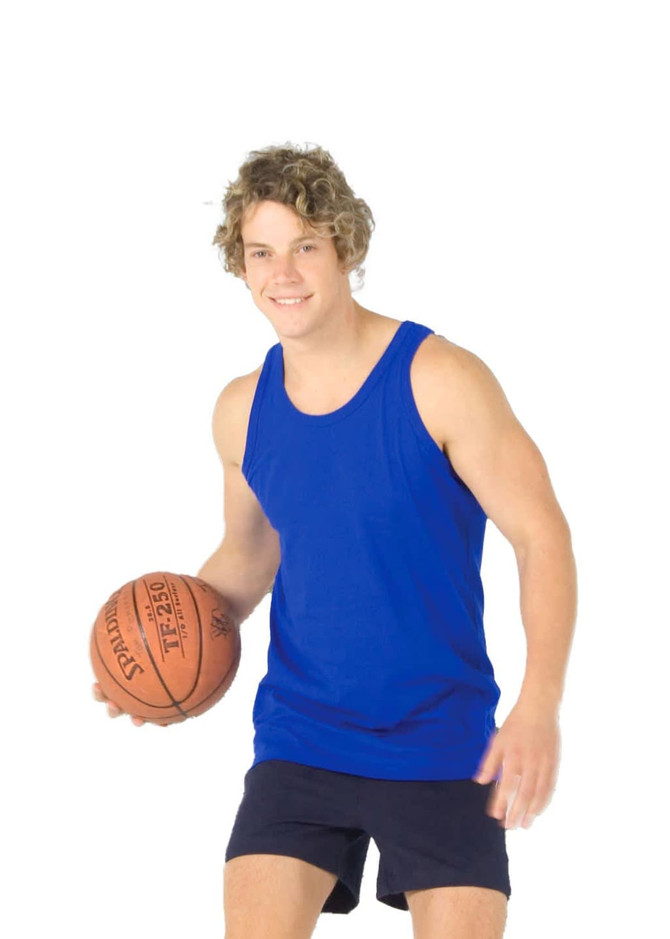 A man in a blue cotton singlet holds a basketball on an outdoor court with a grey wall in the background.
