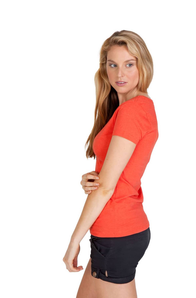 A side view of a woman wearing an orange marl V-neck T-shirt with black shorts. The shirt has a subtle texture and a logo.