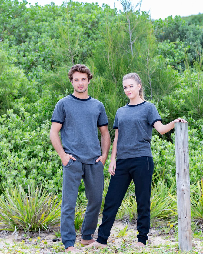 Brushed fleece track pants in grey and black, featured on a man and a woman standing outdoors against greenery.