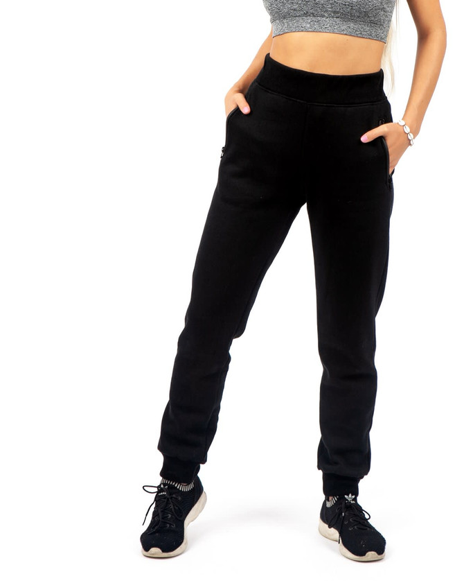 Brushed fleece track pants in black, featuring a fitted design and side pockets, styled with a cropped top and sneakers.