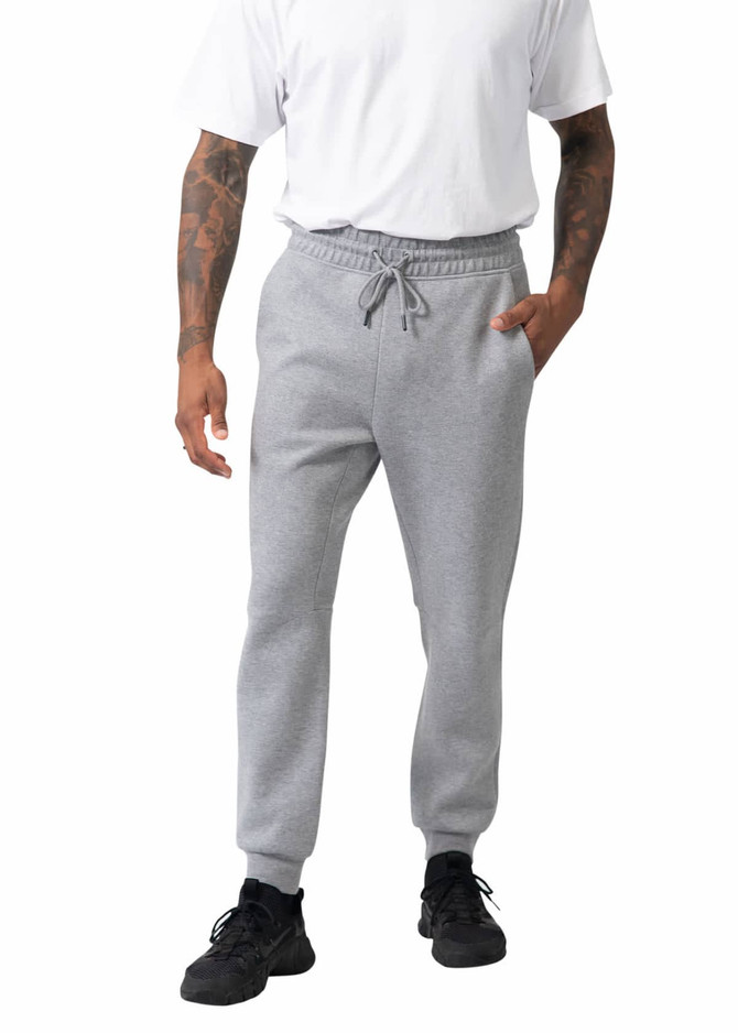 Men's three-layer cotton sandwich pants in grey, featuring an elastic waistband and side pockets. Model wears a white t-shirt.