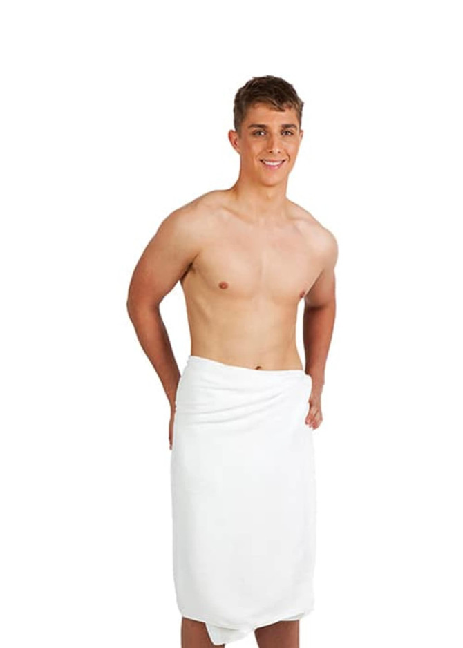 A white bath towel wrapped around a young man standing against a plain background. The man is smiling and shirtless.