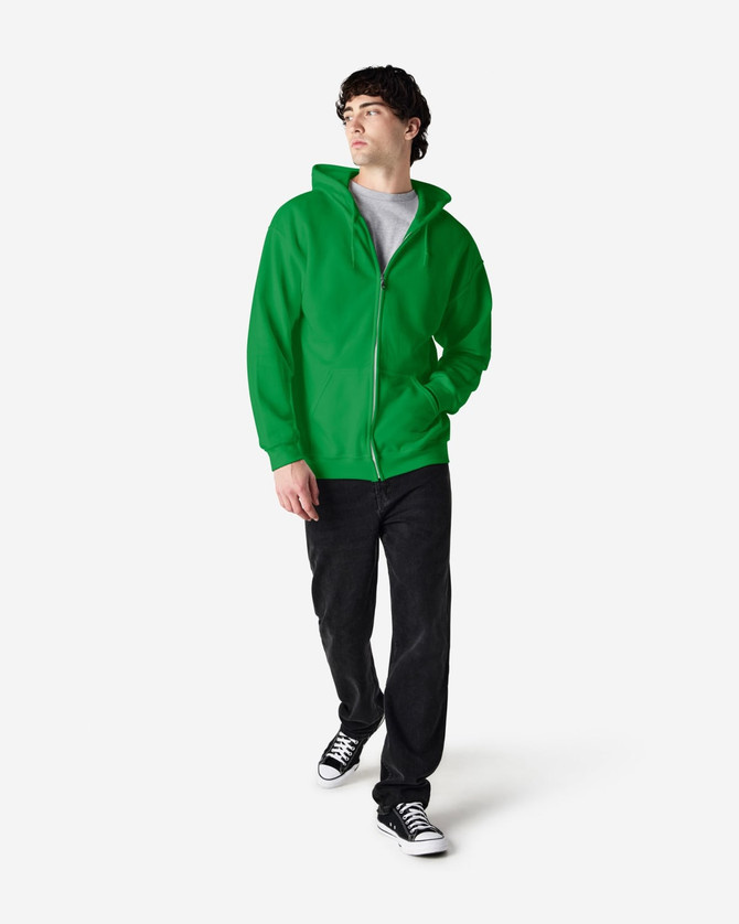 A man wearing a green Gildan Heavy Blend full zip hooded sweatshirt, paired with jeans and sneakers.