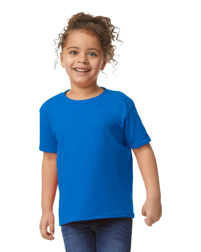 A toddler wearing a bright blue Gildan Heavy Cotton T-Shirt and denim jeans, smiling at the camera.