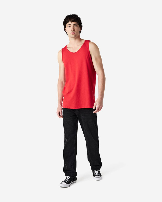 A red Gildan Heavy Cotton adult tank top displayed on a model, paired with black pants and shoes.