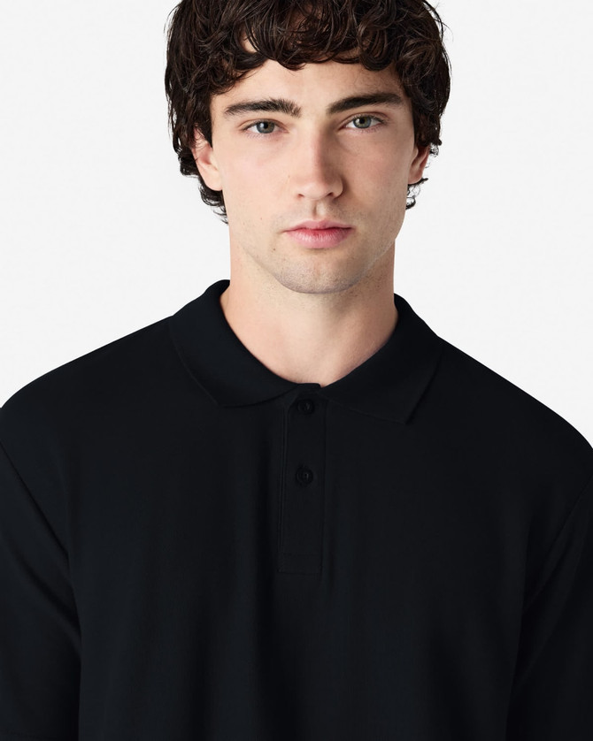 A black Gildan Softstyle adult double pique polo featuring a collared neckline and three buttons. It has a logo on the fabric.