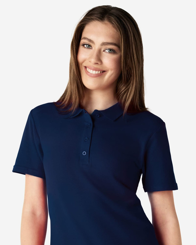 A woman is wearing a navy blue Gildan Softstyle Ladies' Double Pique Polo, featuring a collar and buttons.