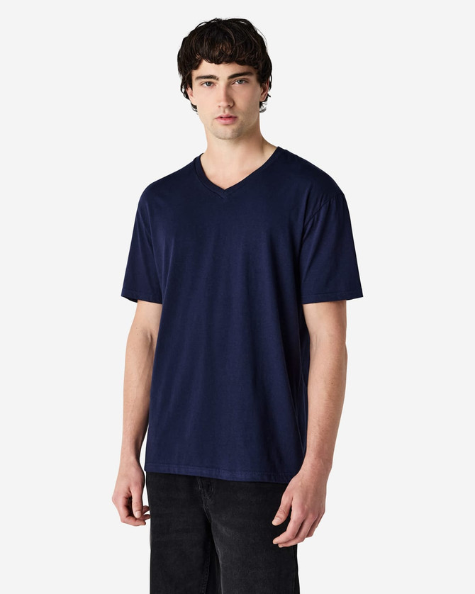A navy Gildan Softstyle adult v-neck t-shirt on a model, featuring a logo on the shirt.