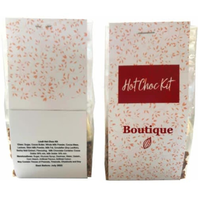 A packaging for a Hot Chocolate Kit featuring a red and white design with chocolate ingredients visible in a clear pouch.