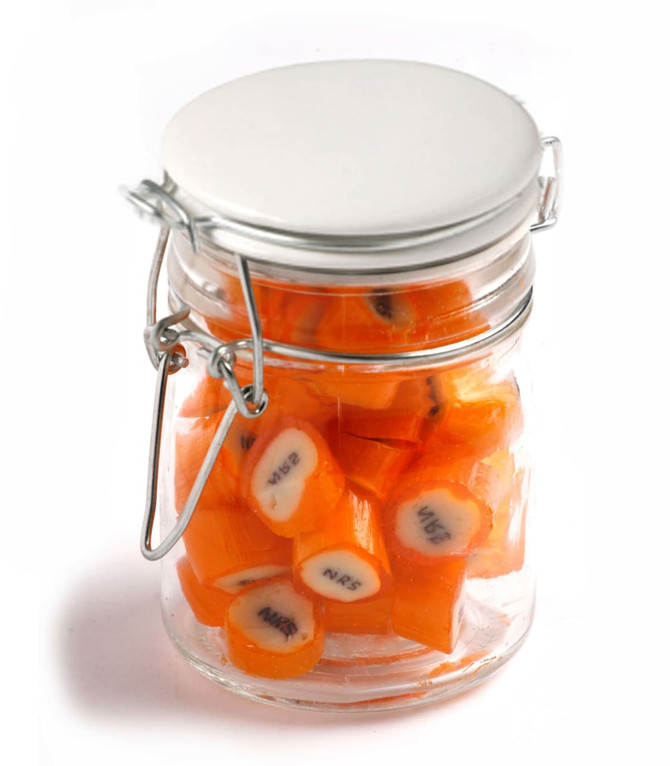 A Clip Lock Jar filled with personalised rock candy pieces in bright orange. Features a silver lid and a clear glass design.
