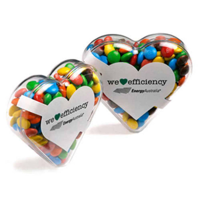 Acrylic heart-shaped container filled with colourful M&Ms, featuring a logo on the front.