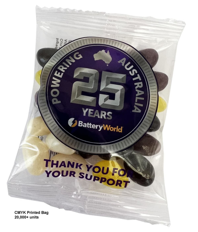 A clear bag containing assorted jelly beans in black, white, and yellow, featuring a logo and a decorative label.