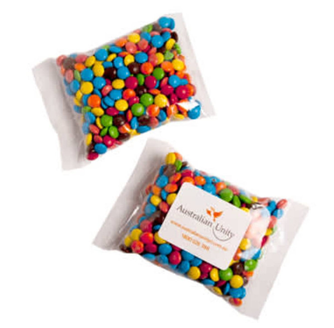 A clear bag containing colourful Mini M&Ms in various shades, including blue, yellow, green, and red.