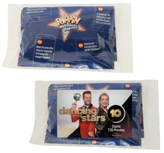 A pack of microwave popcorn, featuring blue packaging with illustrations and a logo, and a promotional card.