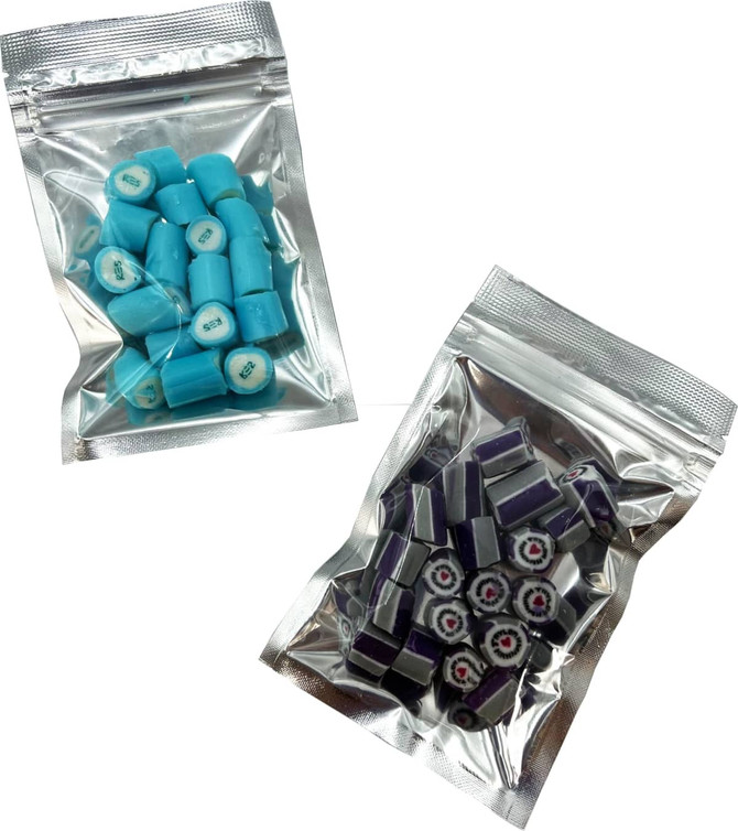 Silver zip lock bags containing blue and purple rock candy pieces. Each bag features a clear design and a branding logo.