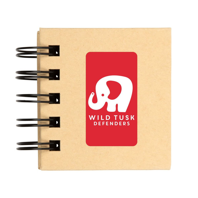A spiral-bound notebook with a kraft cover featuring a white elephant logo and the text "WILD TUSK DEFENDERS."