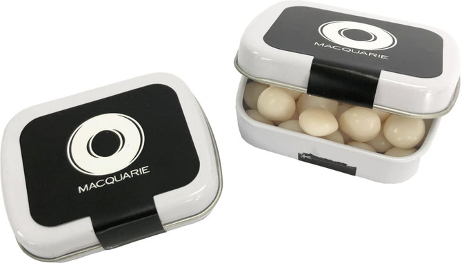 A small rectangular tin with a black lid, filled with white mints. The tin features a branding logo on top.