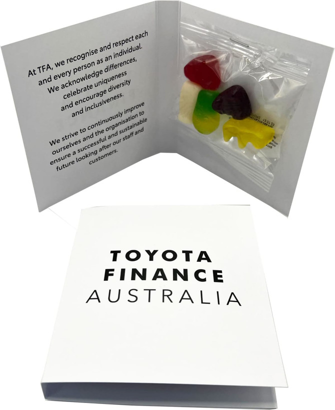 A gift card packet featuring a selection of colourful mixed lollies, enclosed in a white folder with branding.