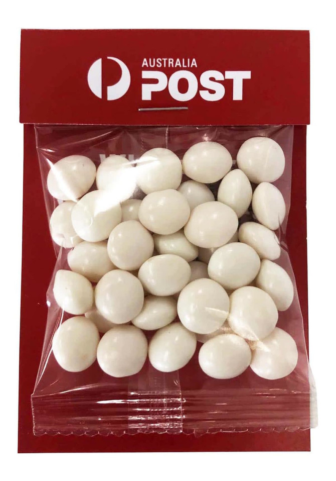 A clear bag containing white chewy mint candies, packaged with a red backing and featuring a logo.