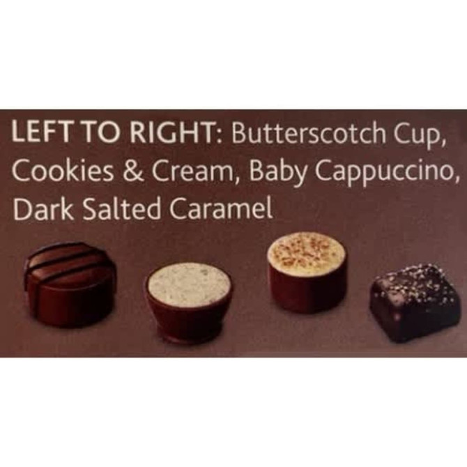 A box of four chocolates in brown and white: Butterscotch Cup, Cookies & Cream, Baby Cappuccino, Dark Salted Caramel.