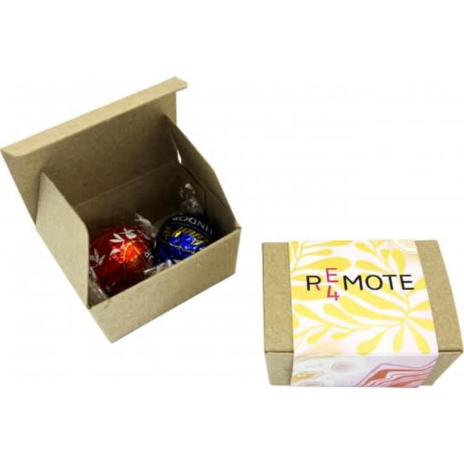 A small brown box containing two chocolate balls, one red and one blue, with a branded outer sleeve.
