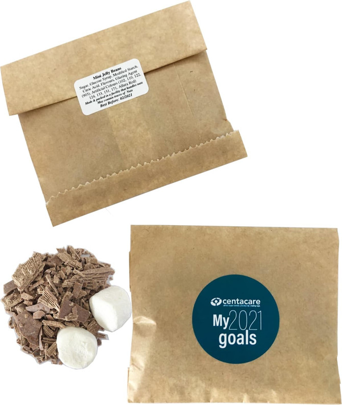 Kraft paper bag containing Lindt hot chocolate flakes and marshmallows, with a circular logo.